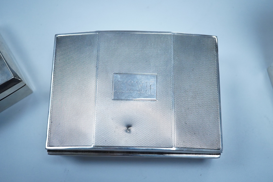 Three assorted George V/George VI silver mounted cigarette boxes, including two with engine tuned covers, the largest by Joseph Gloster Ltd, Birmingham, 1946, 12.8cm.